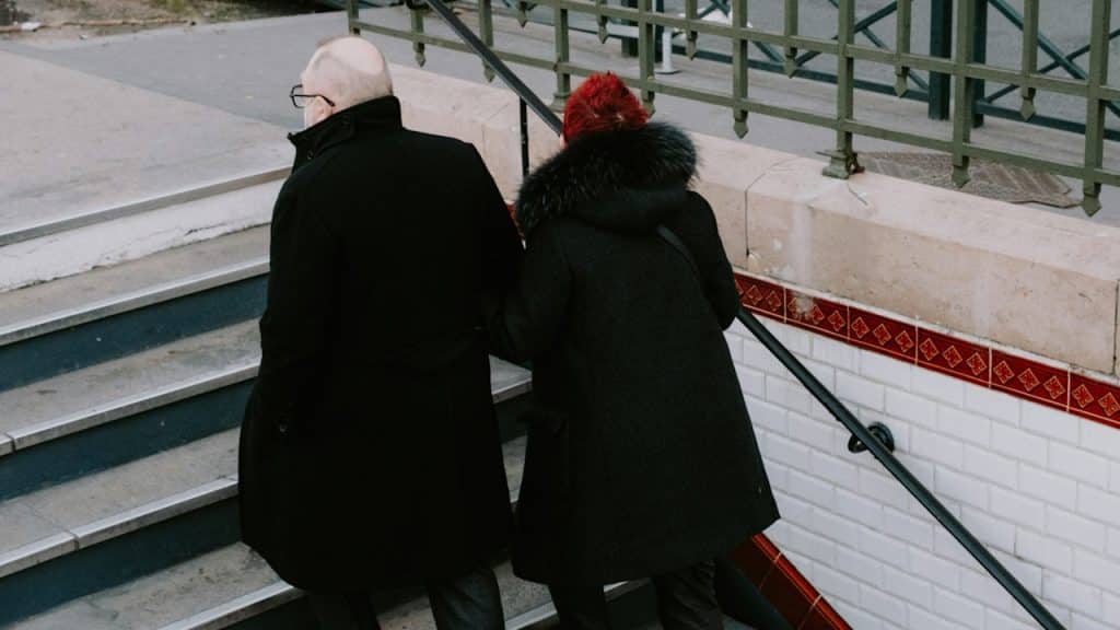 An older couple walking up a flight of stairs.