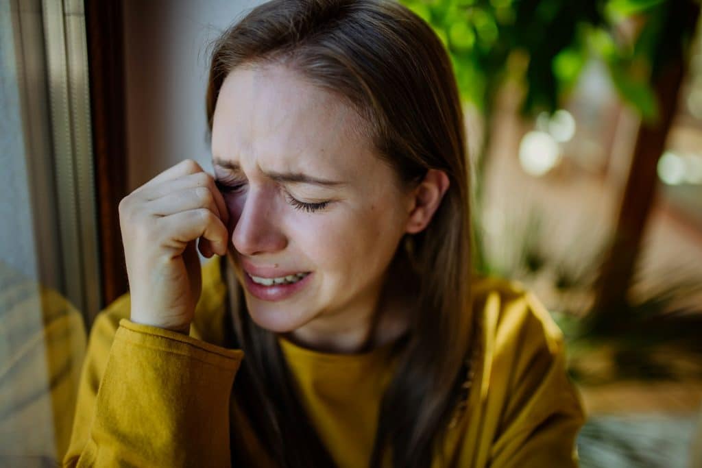 A woman crying at home.