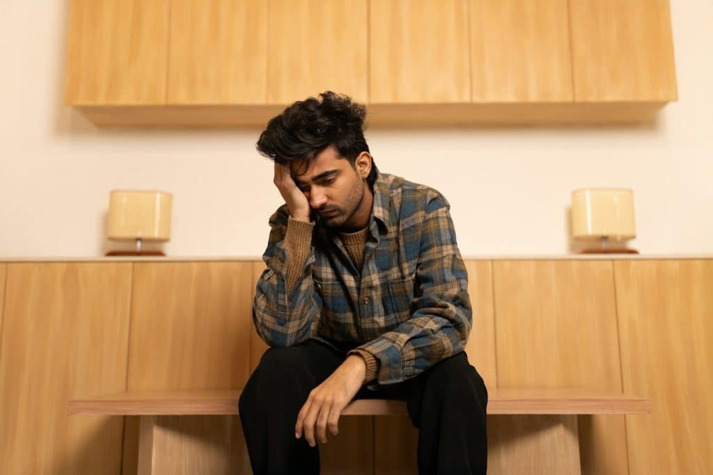 A man sitting on a wooden bench.