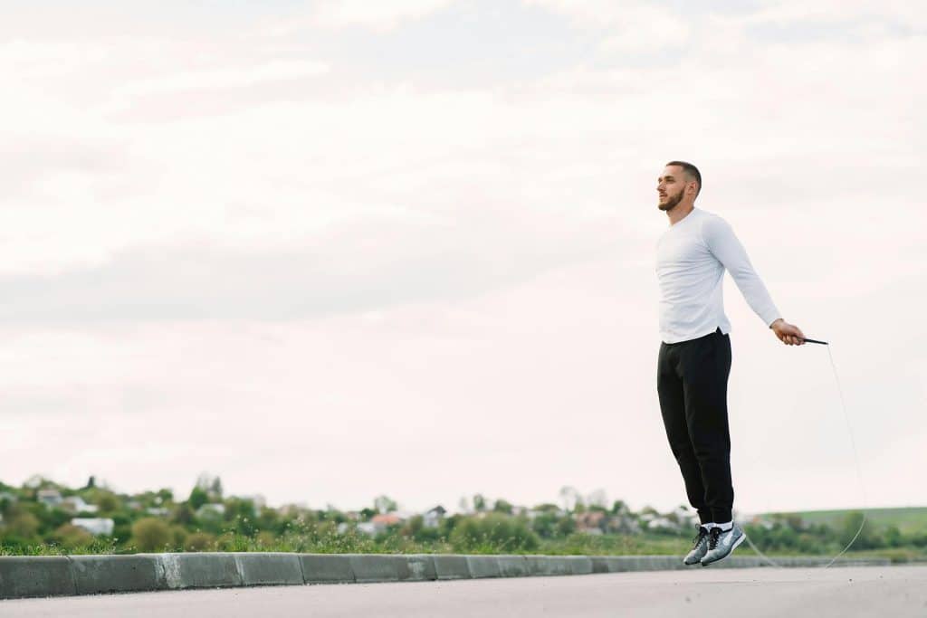 A man exercising with a jumping rope.