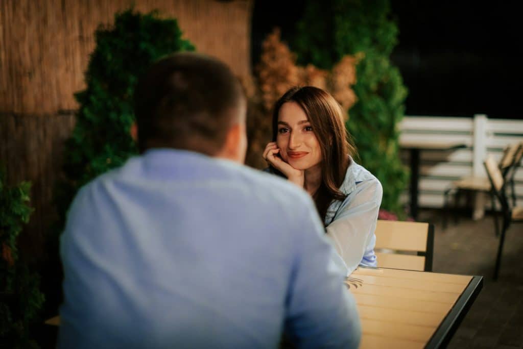 A woman looking lovingly at the man sitting across from her.