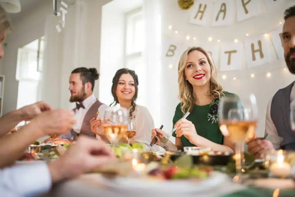 A family sitting at a table in an indoor birthday celebration.