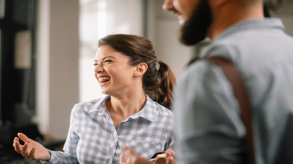 Colleagues laughing together in the office