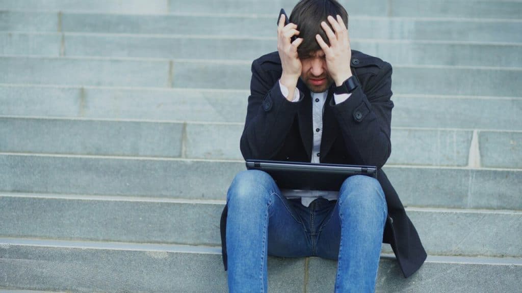A man looking stressed with his laptop
