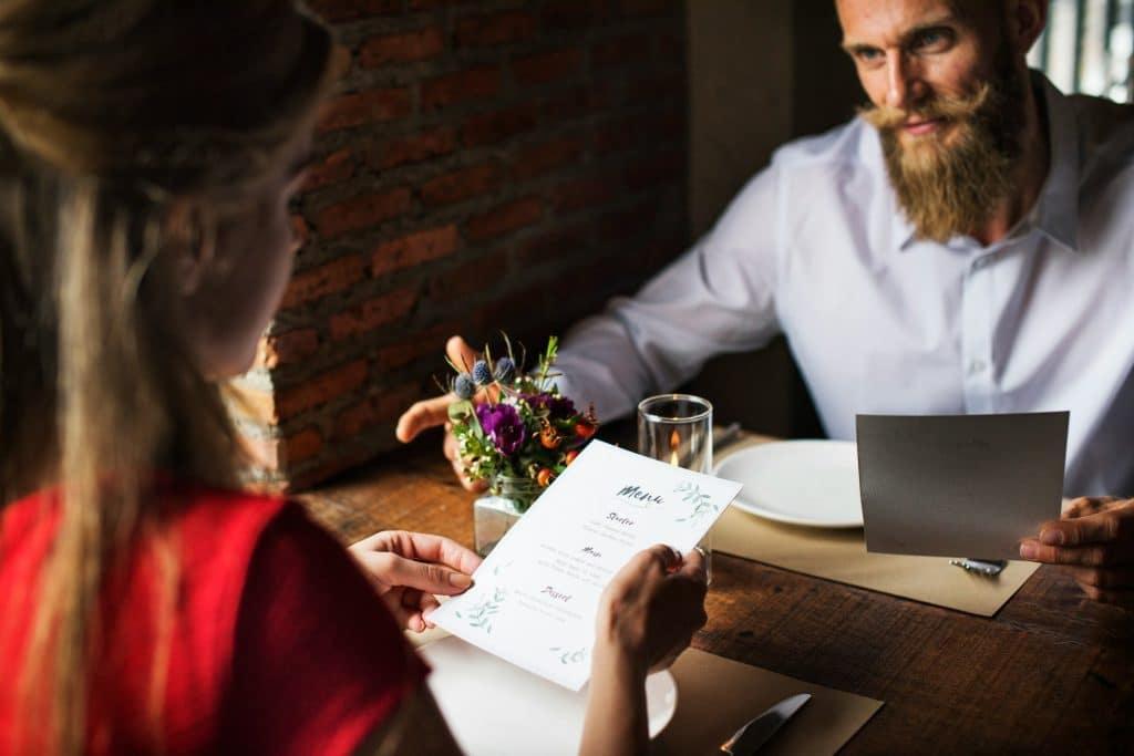 A couple looking at the menu while sitting at a table in a restaurant.
