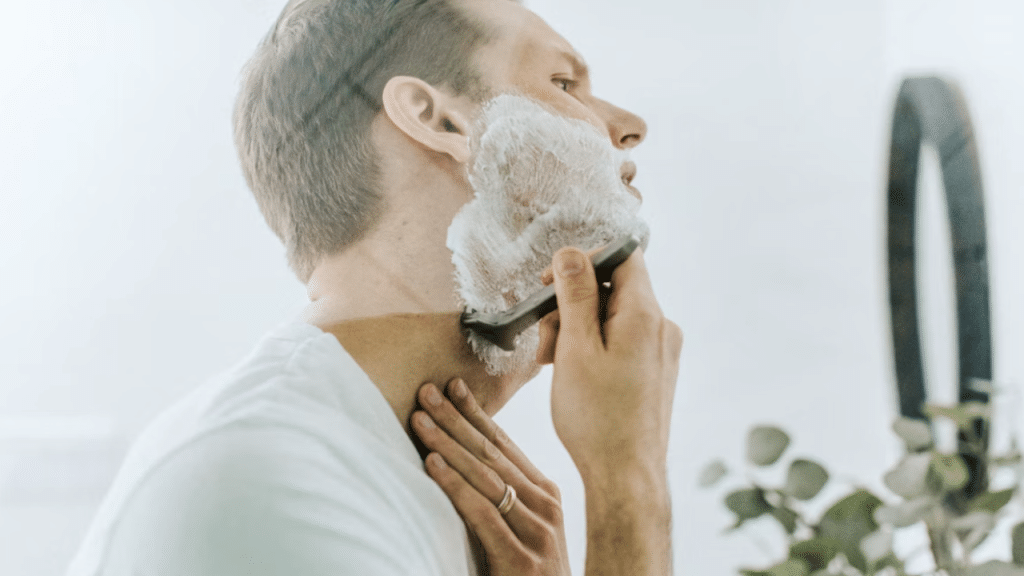 A man shaving in front of a mirror 