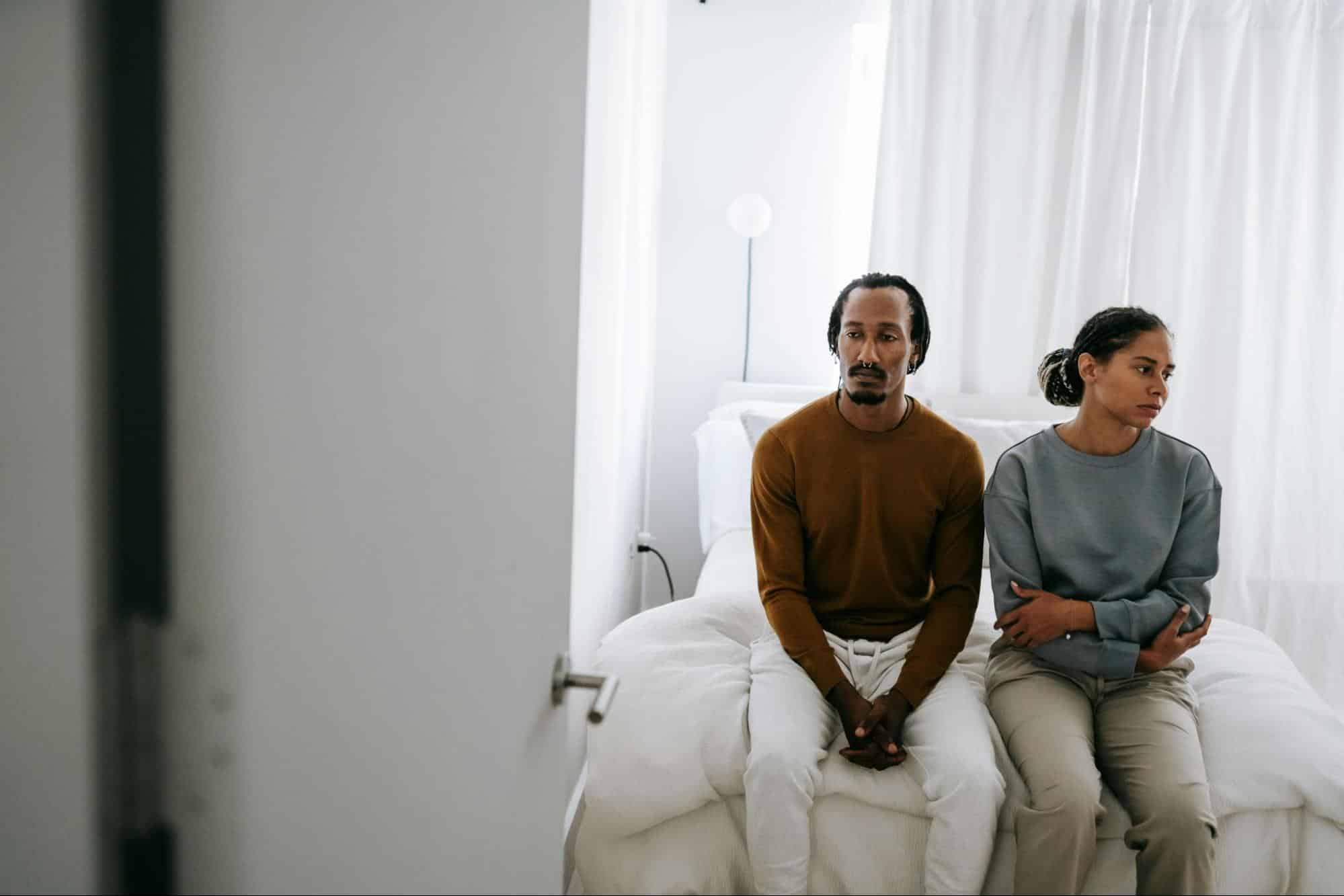 A man and woman sitting at the bed