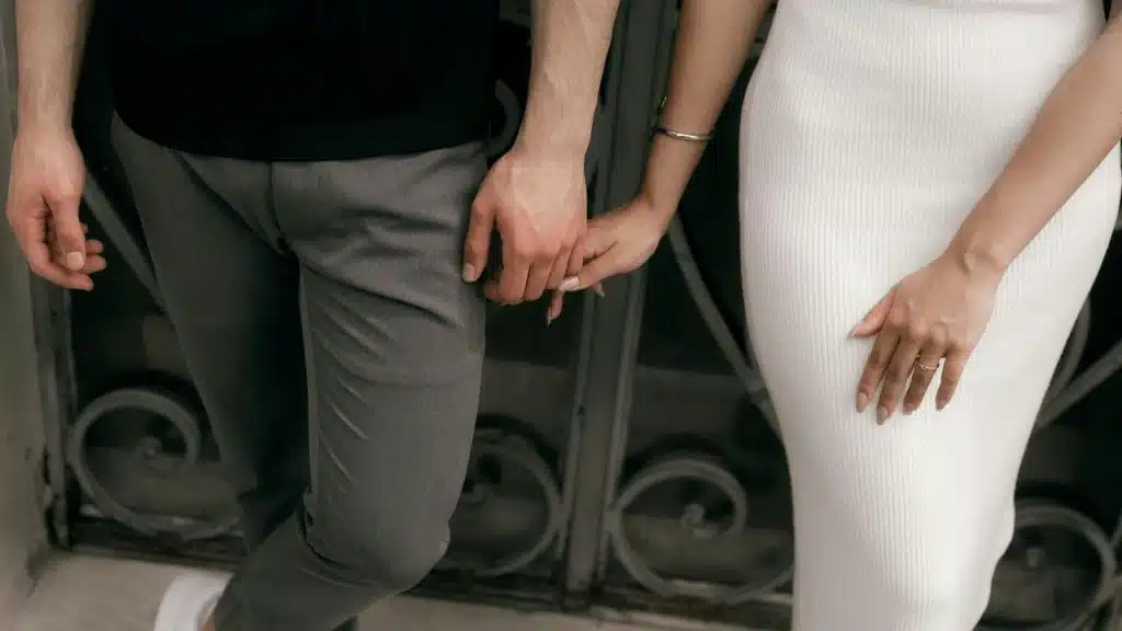 A couple standing close together holding hands.