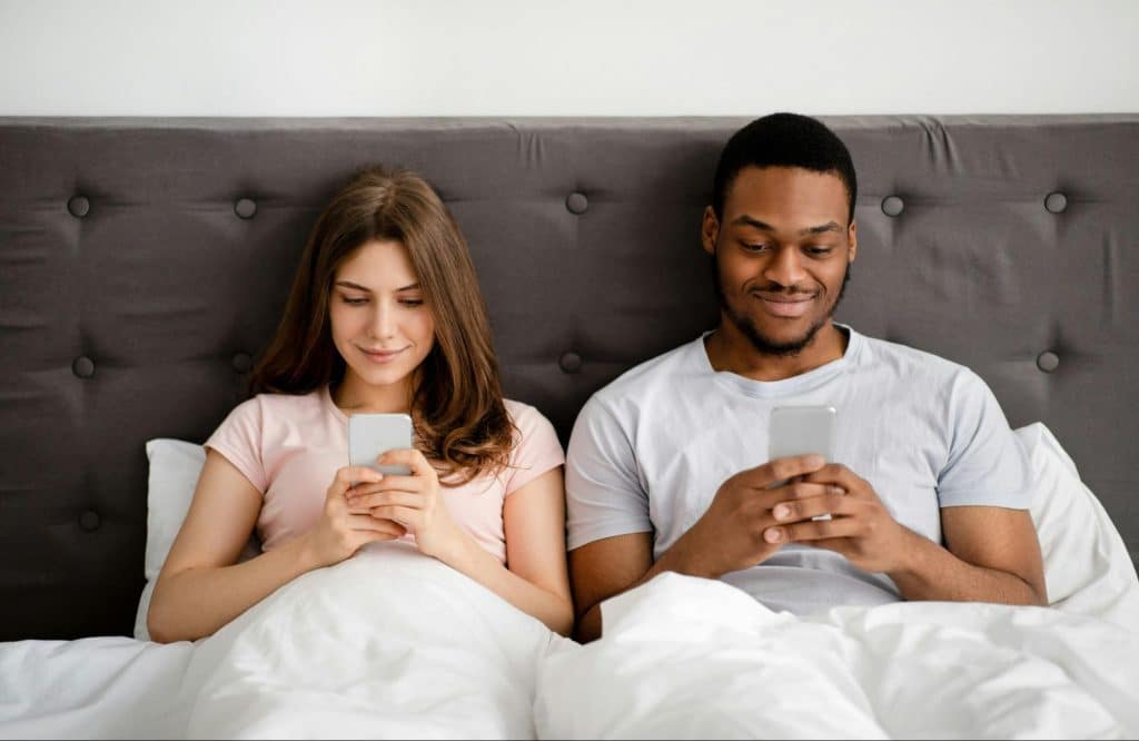 A man and woman busy using a phone