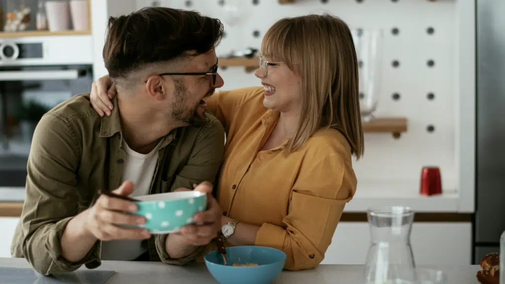 A couple laughing together in the kitchen