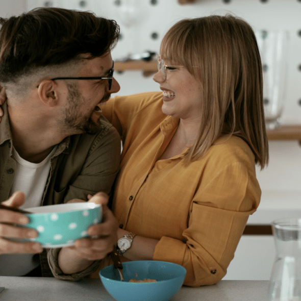 A couple laughing together in the kitchen