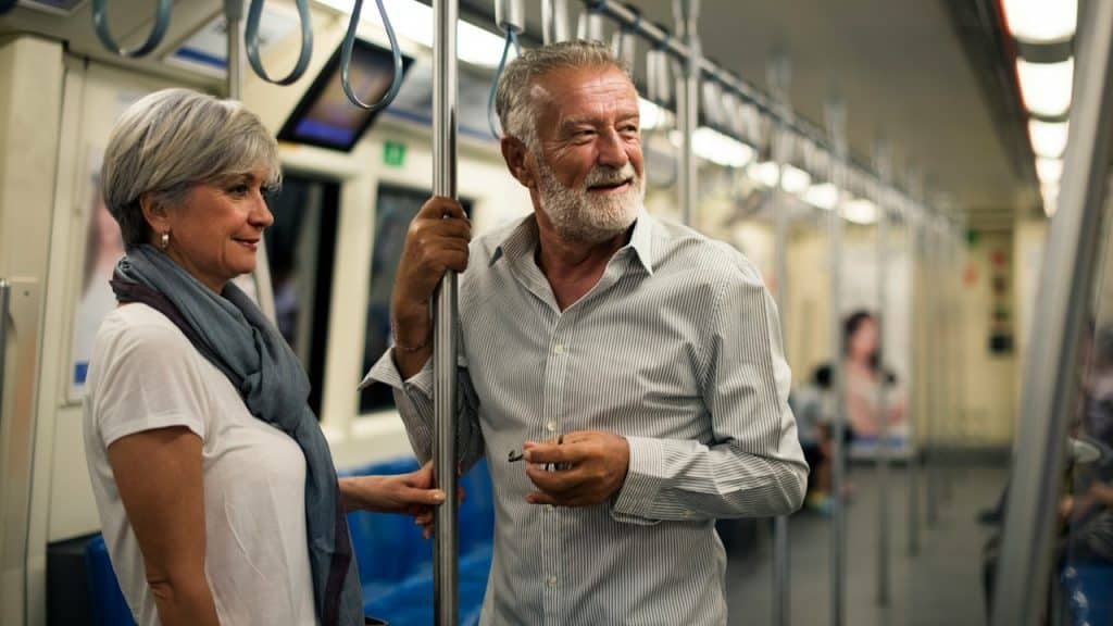 A senior couple traveling inside a train subway.