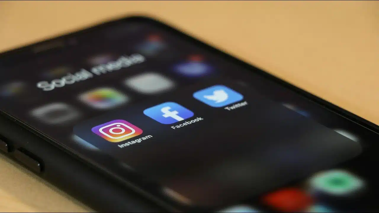 A smartphone screen showing Instagram, Facebook, and Twitter apps in a social media folder.