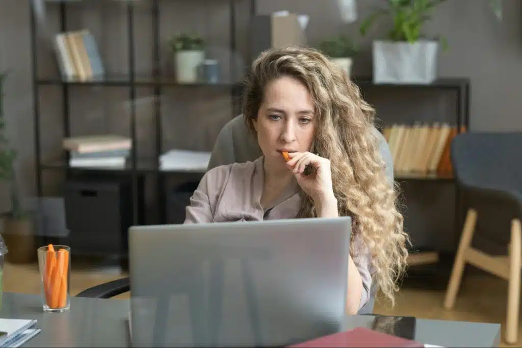 A woman thinking while looking at the laptop