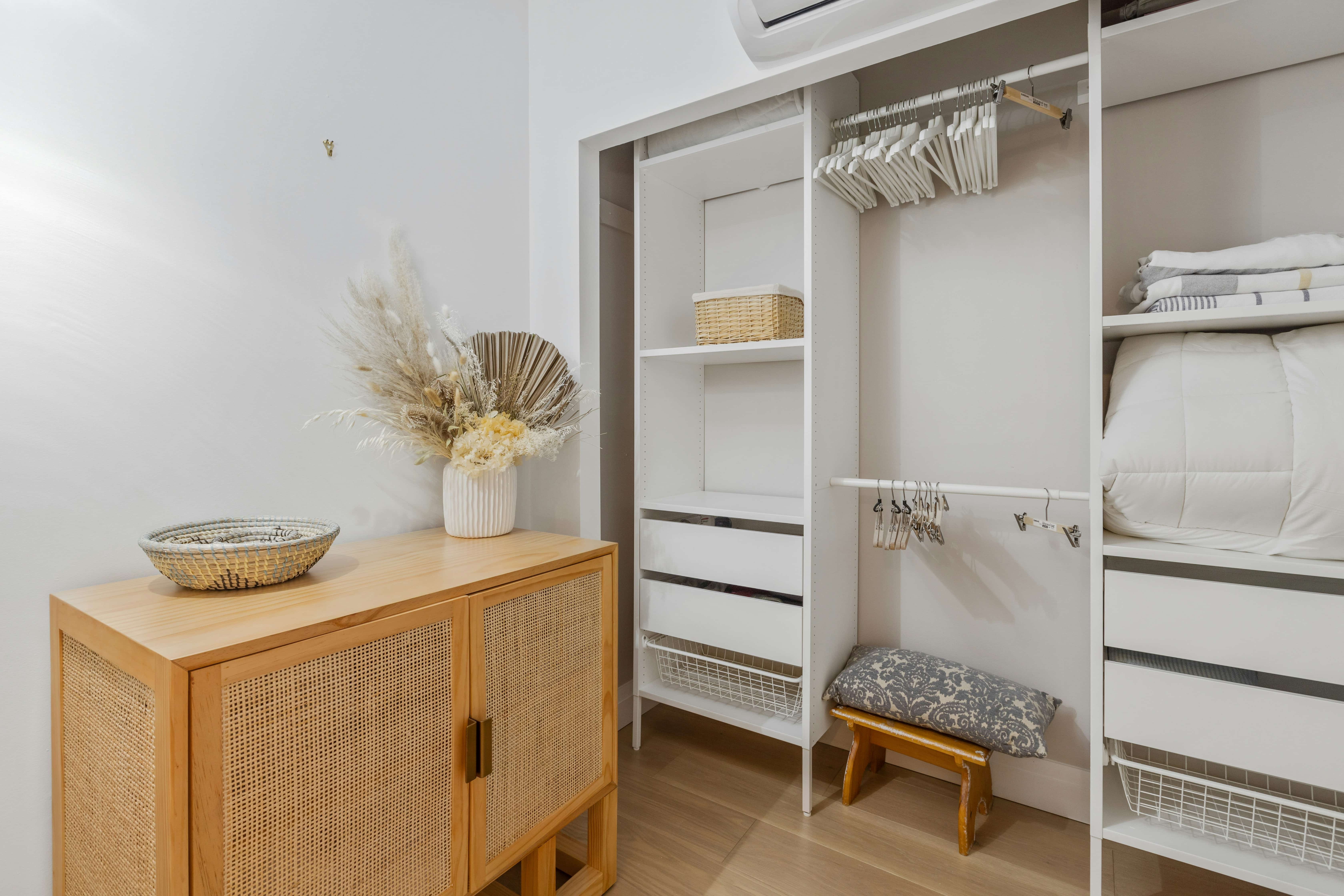 A closet and wooden bedside cabinet.