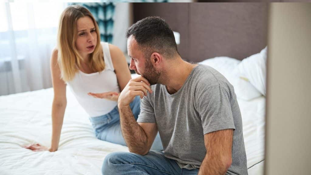 A woman complaining to a man as they sit on a couch.