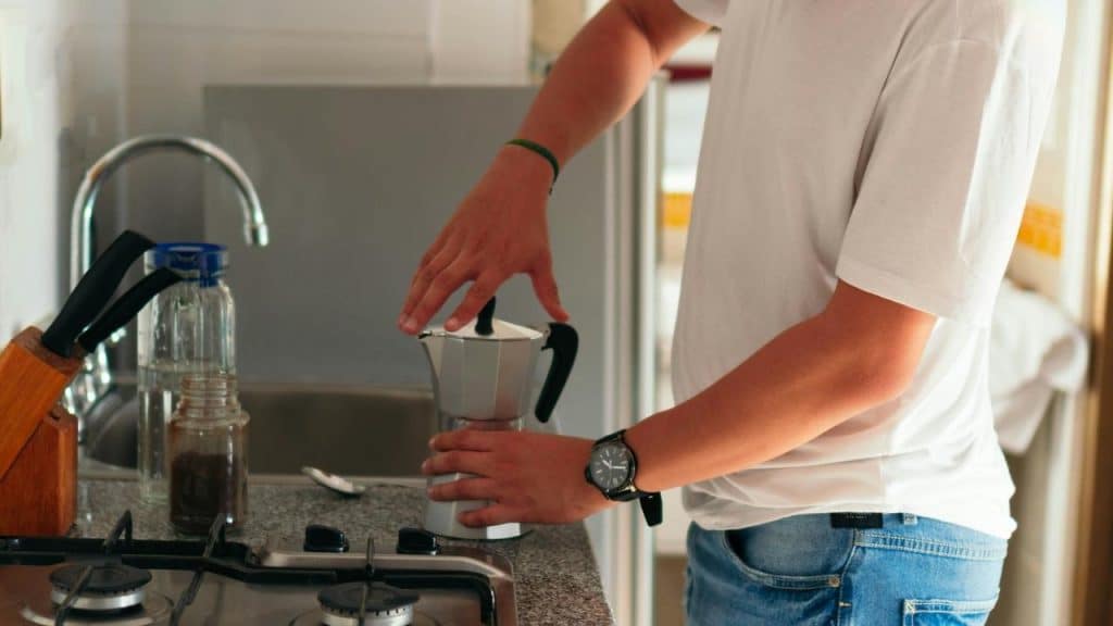 A person making coffee with a moka pot.