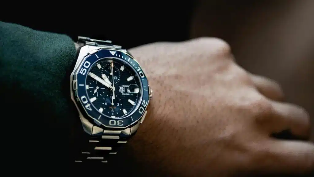 A wristwatch with a blue dial on a wrist.