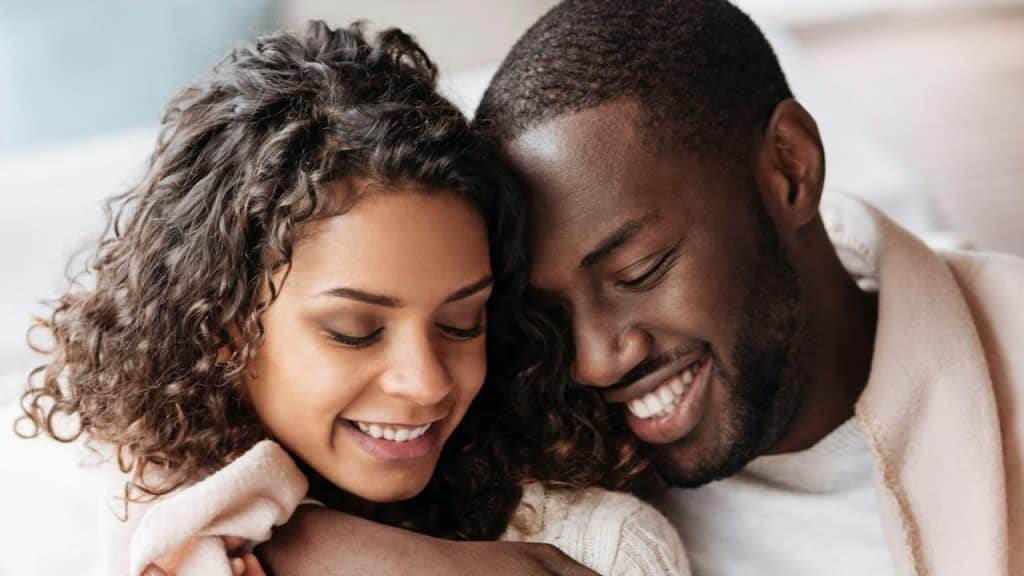 A man snuggling with a woman.