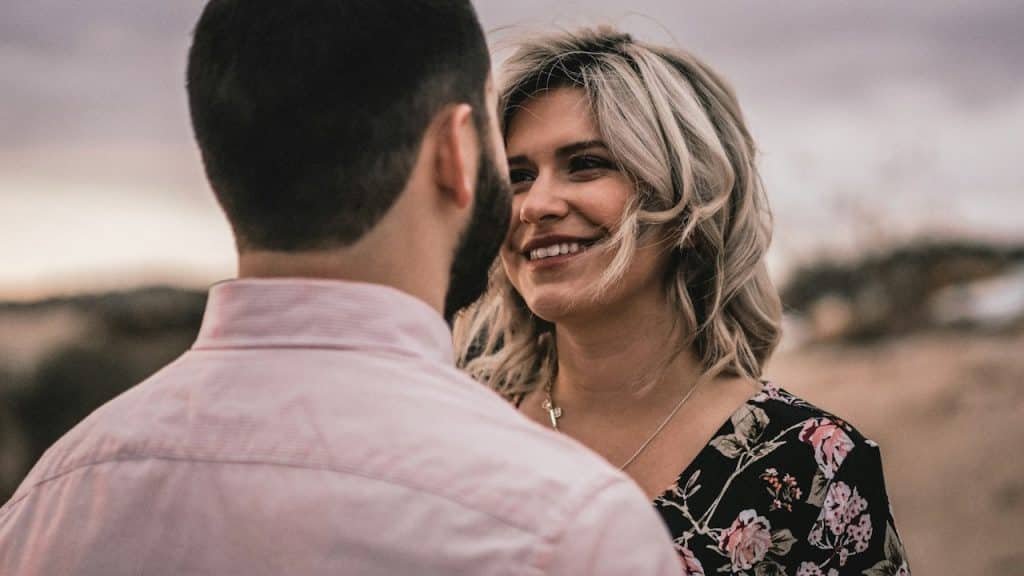 A woman smiling at a bearded man. 