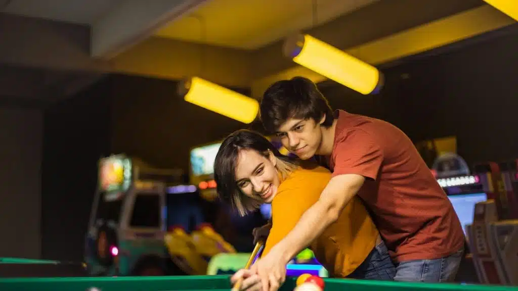 A couple playing snooker together.