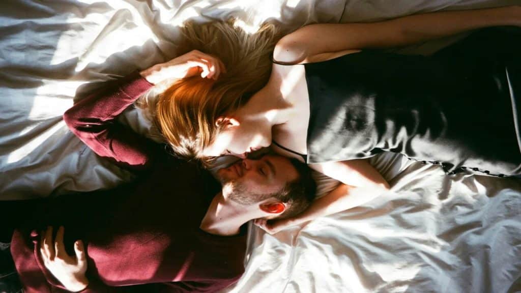 A couple looking at each other in bed