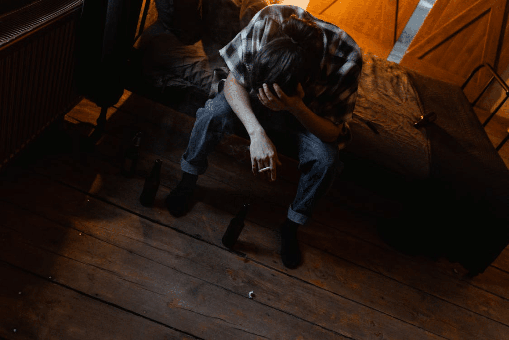 A distressed man sitting on the bed with a cigarette