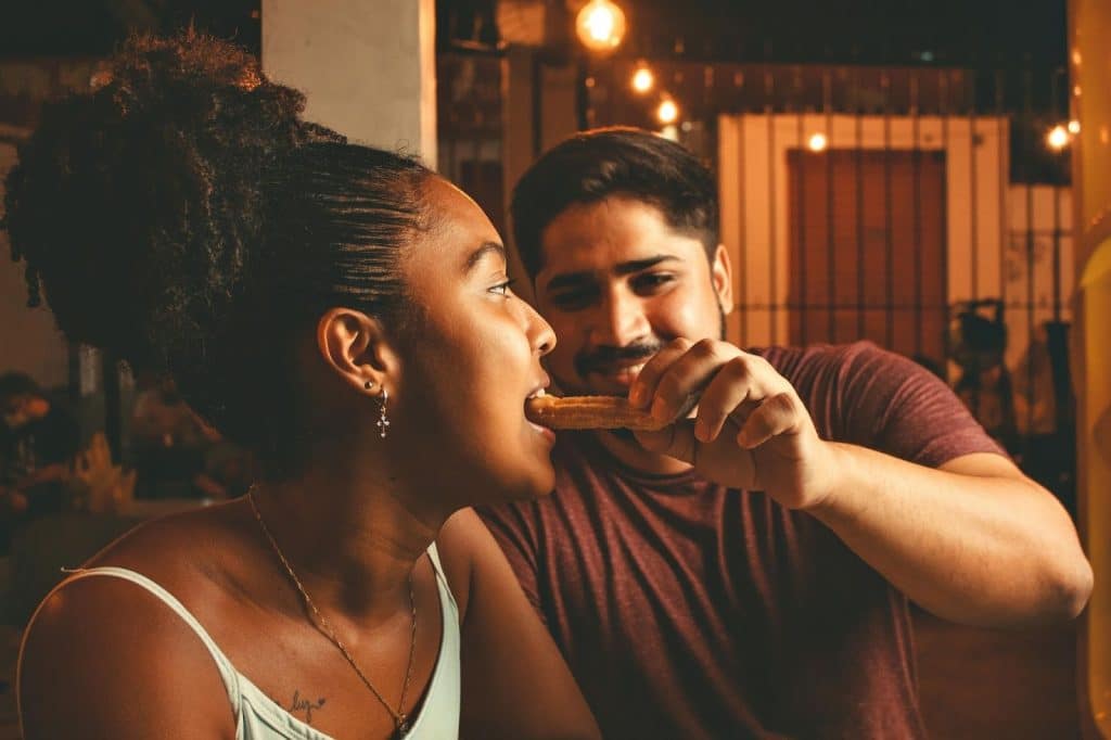 A man feeding a woman