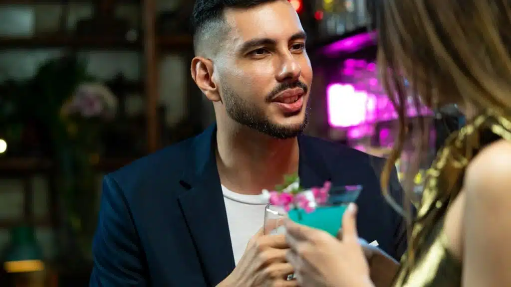 A couple drinking alcoholic cocktails at a bar.