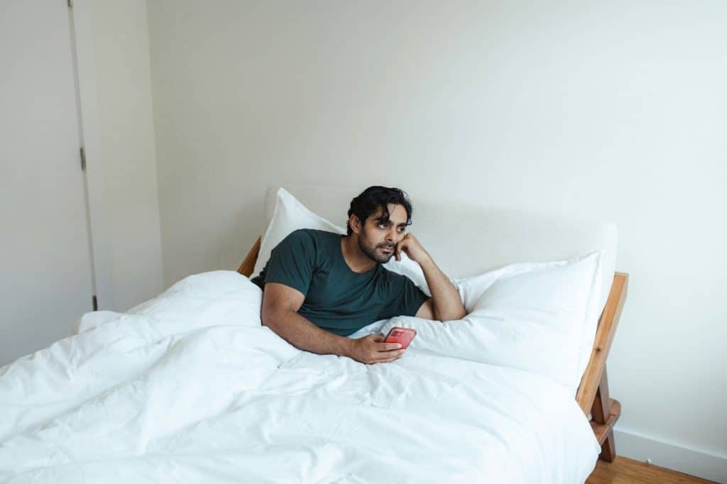 A man laying in bed and thinking