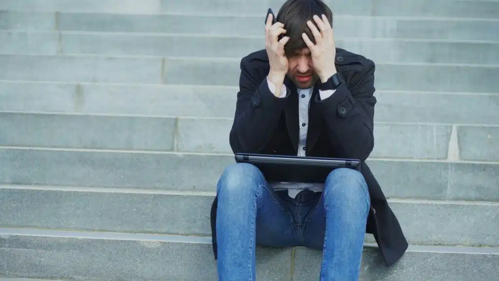 A man looking stressed with his laptop