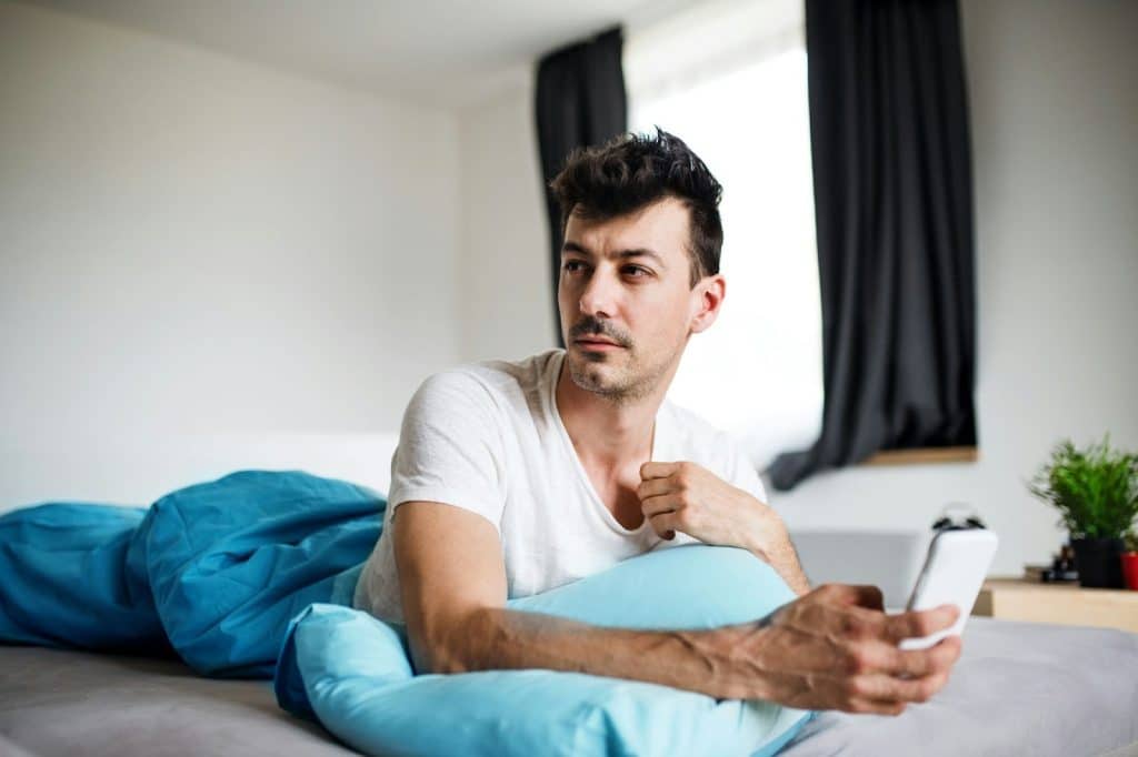 A man using a phone and worrying for something