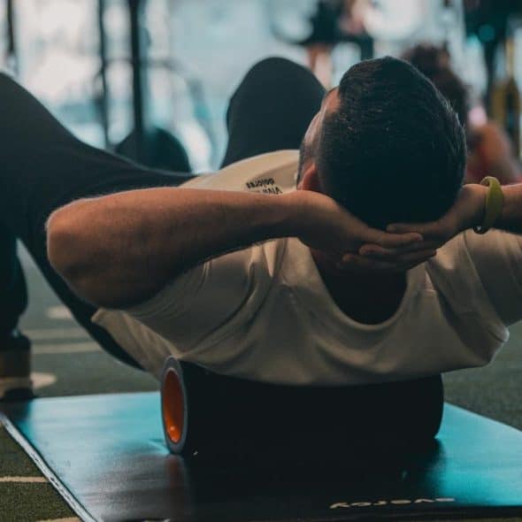 A person doing a crunch exercise on a mat in a gym.