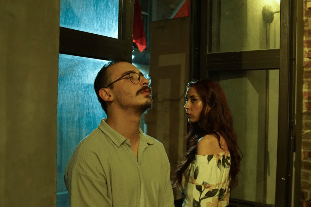 A man and woman standing in front of a window