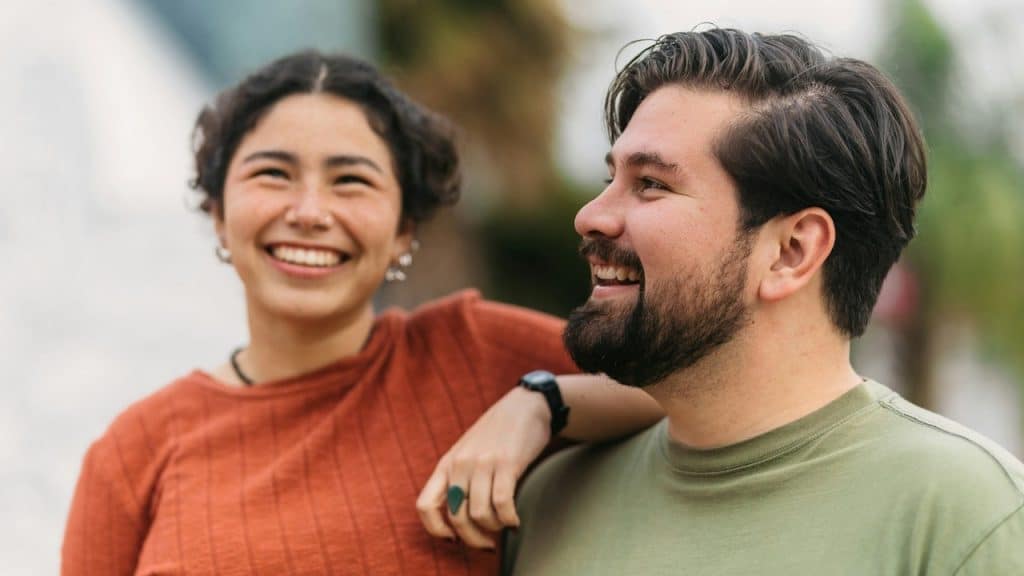 A man and a woman smiling at each other.
