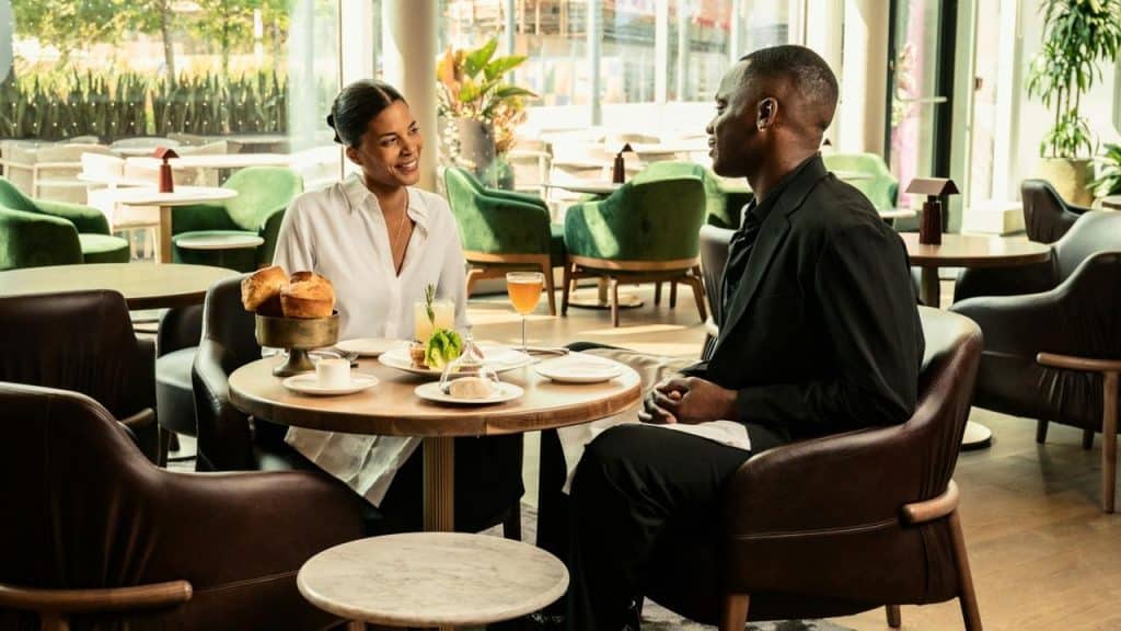 A couple smiling and talking over a meal at a modern restaurant table.