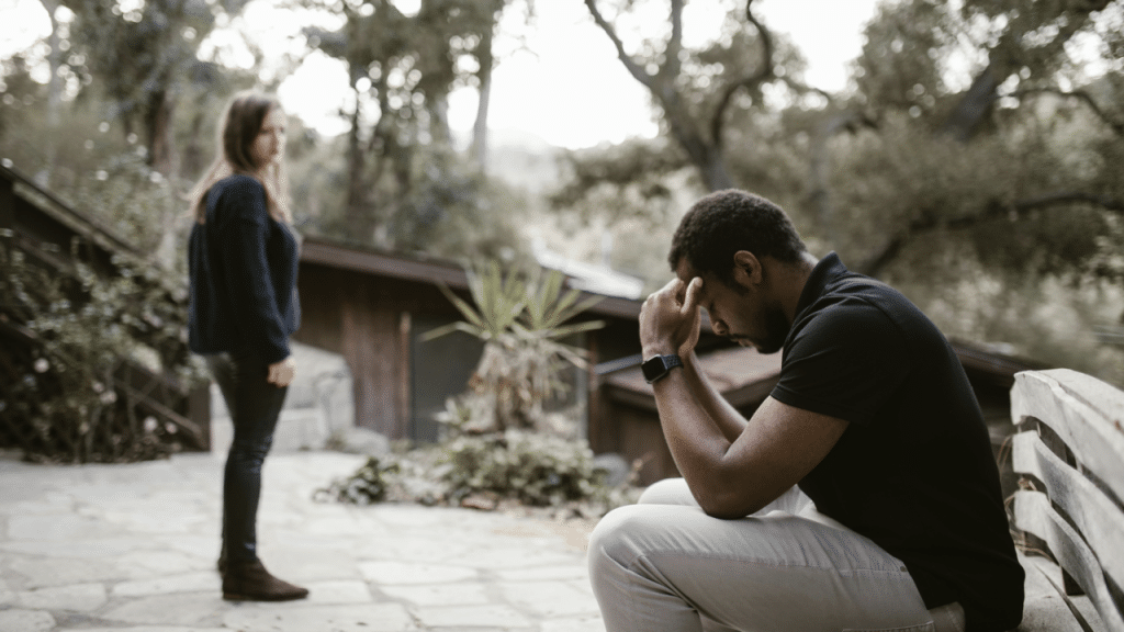 A woman walking away from her upset boyfriend