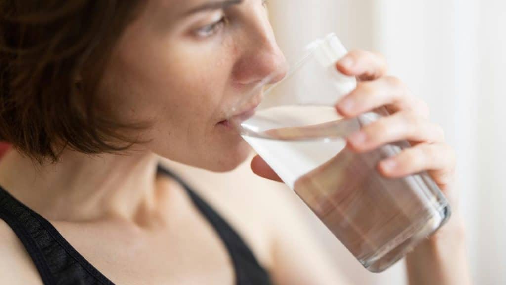 A woman drinking a glass of water.