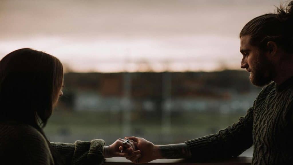 A couple holding hands at home