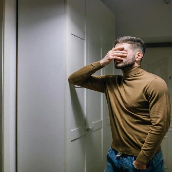 A man with his hand on his face