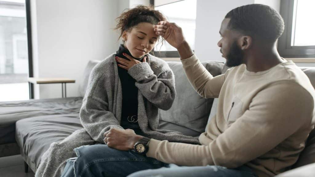 A man checking his girlfriend’s temperature