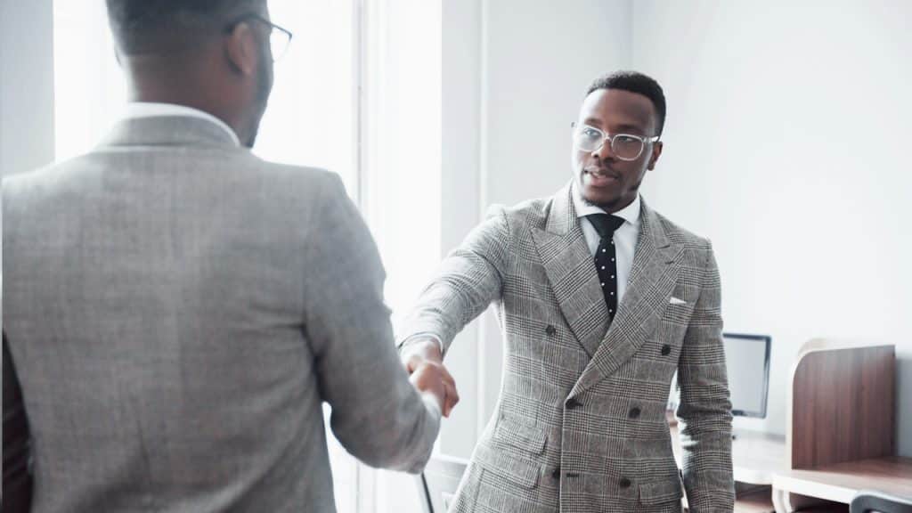 Two handsome, cheerful African American executive businessmen at the workspace office.