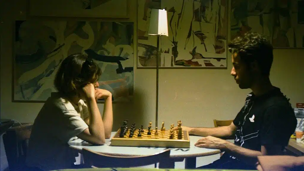 A couple plays chess together indoors.