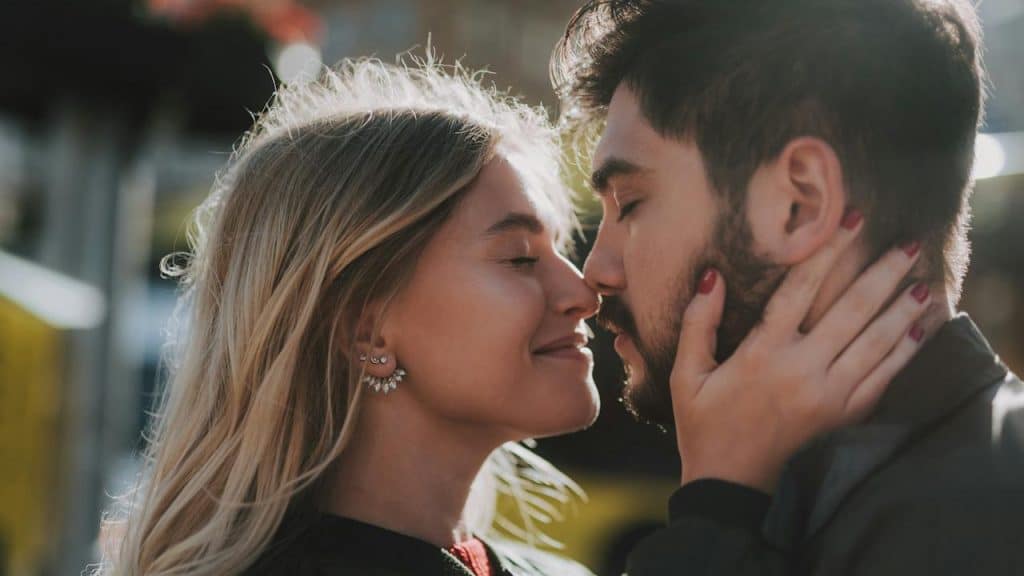 A couple touching noses and about to kiss.