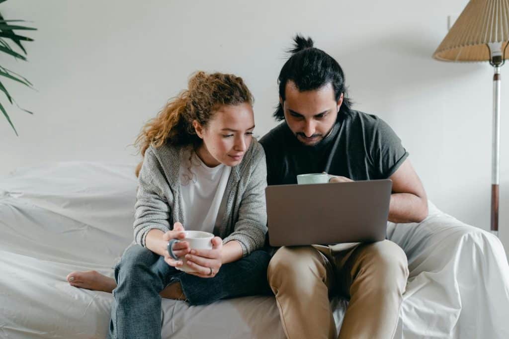 A man and woman looking at the laptop