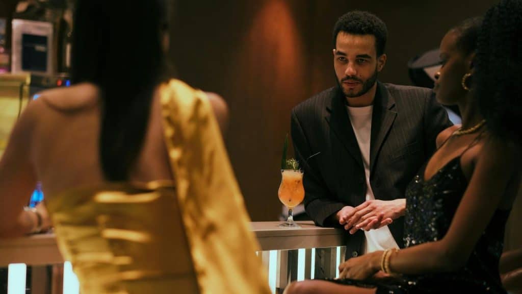A stylish group socializing at a dimly lit bar with cocktails.