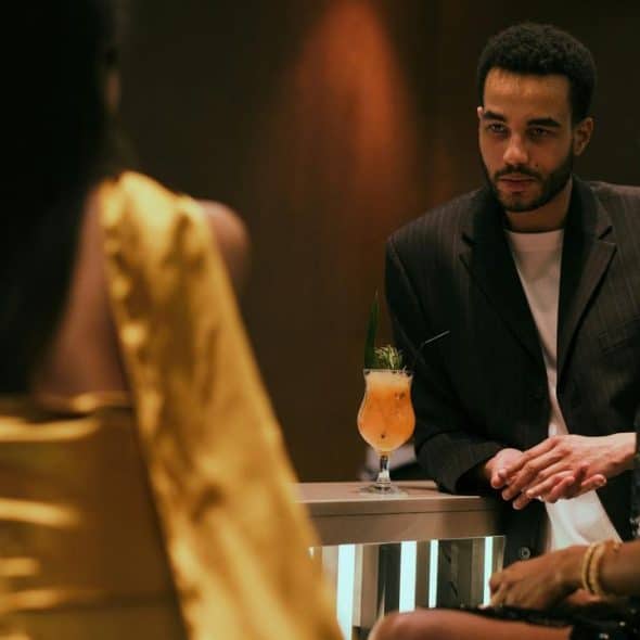A stylish group socializing at a dimly lit bar with cocktails.