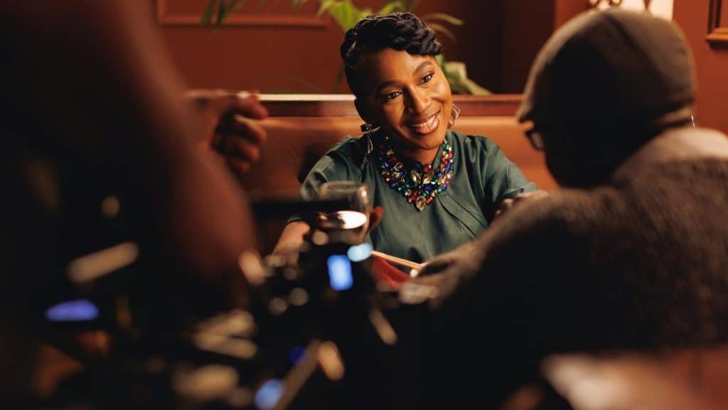 A woman smiling during a conversation at a cozy restaurant table.