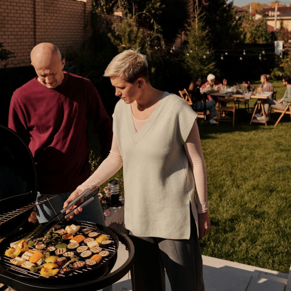 A couple grilling outside