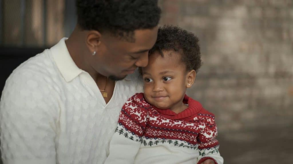 A father affectionately holding his young son, sharing a warm and tender moment.